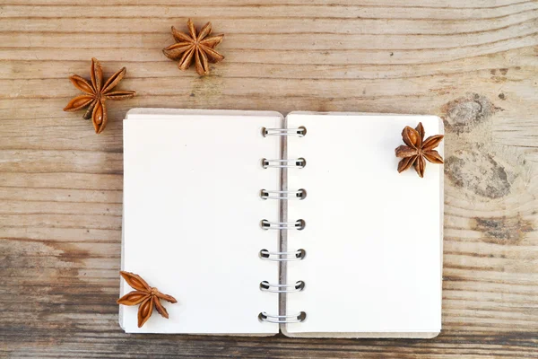 Um caderno espiral retro vazio com papel velho e estrelas de anis na mesa de madeira — Fotografia de Stock