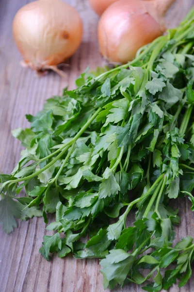 Bunch of fresh green parsley with onions on wooden table — Stock Photo, Image