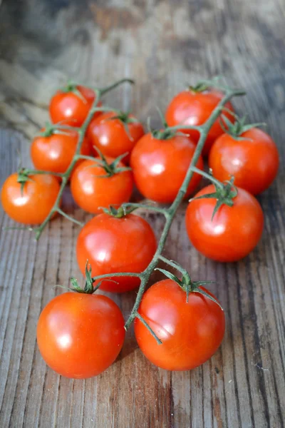 一群小红色的樱桃番茄，木制的桌子上 — 图库照片