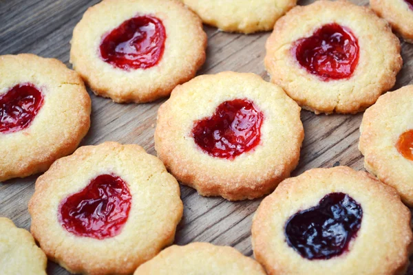 Galletas caseras con mermelada en forma de corazón en mesa de madera — Foto de Stock