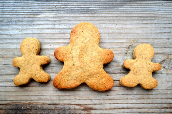 Galletas de jengibre en forma de hombre sobre mesa de madera —  Fotos de Stock