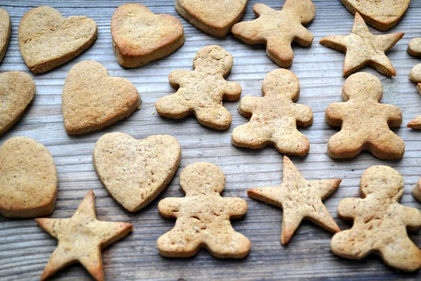 Galletas de jengibre en forma de corazón, estrella y hombre sobre mesa de madera —  Fotos de Stock