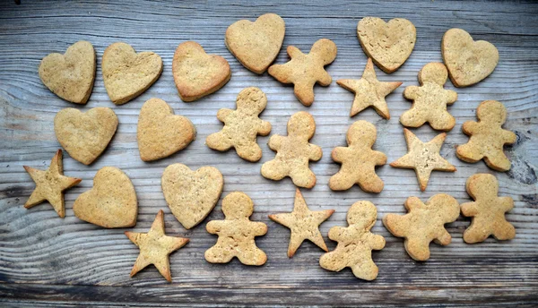 Galletas de jengibre en forma de corazón, estrella y hombre sobre mesa de madera —  Fotos de Stock