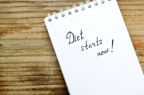 Diet concept with a notebook saying to start loosing weight on wooden table — Stock Photo, Image