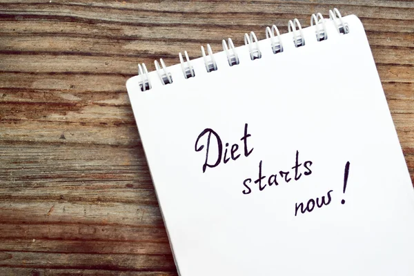 Diet concept with a notebook saying to start loosing weight on wooden table — Stock Photo, Image