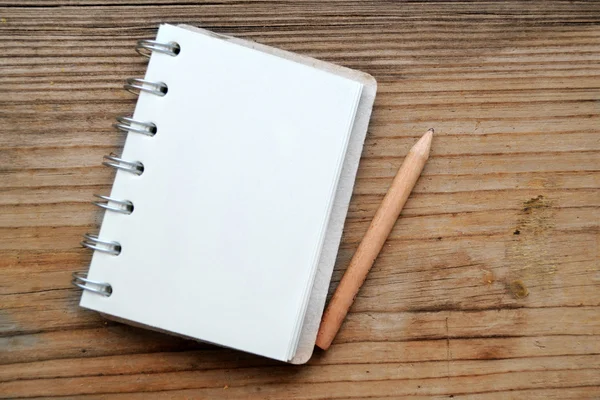 Um caderno retrô vazio com papel velho e lápis pequeno — Fotografia de Stock