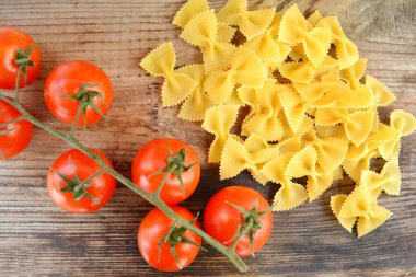 Küçük kırmızı kiraz domates ve kelebek makarna farfalle ahşap tablo şeklinde