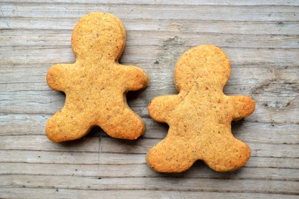 Galletas de jengibre en forma de hombre sobre mesa de madera —  Fotos de Stock