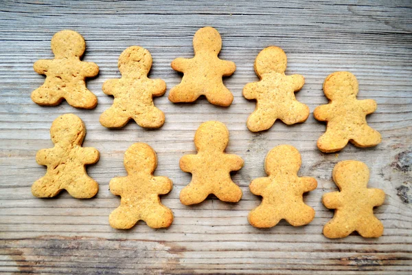 Galletas de jengibre en forma de hombre sobre mesa de madera —  Fotos de Stock