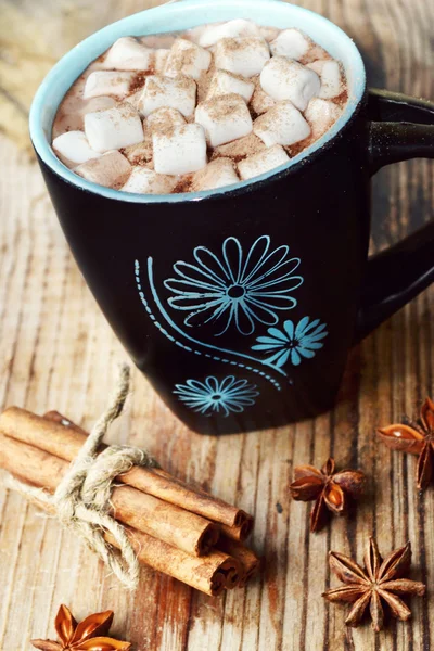 Tasse noire et bleue de cacao chaud avec guimauves, anis étoilé et cannelle — Photo