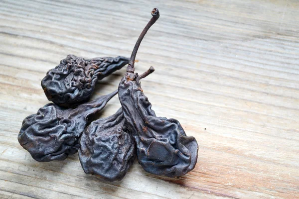 Dark dry pears on wooden background — Stock Photo, Image