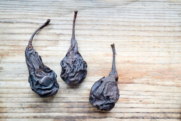 Dark dry pears on wooden background — Stock Photo, Image