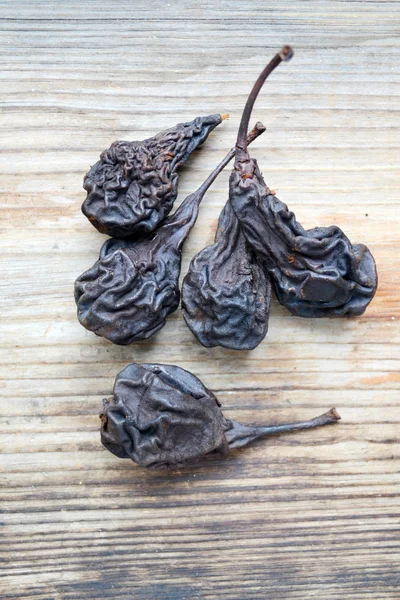 Dark dry pears on wooden background — Stock Photo, Image