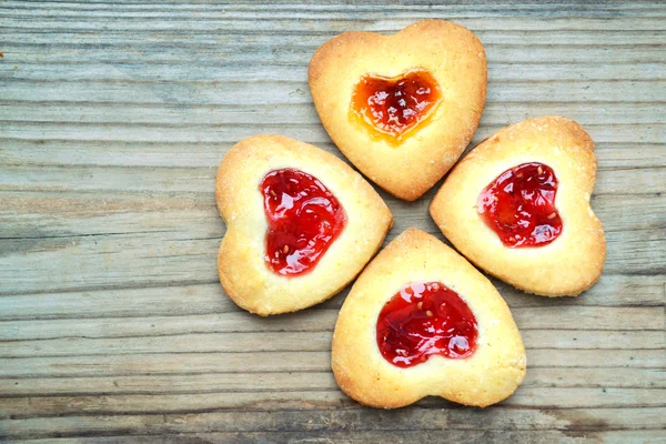 Homemade cookies with heart shaped jam on wooden table — Stock Photo, Image