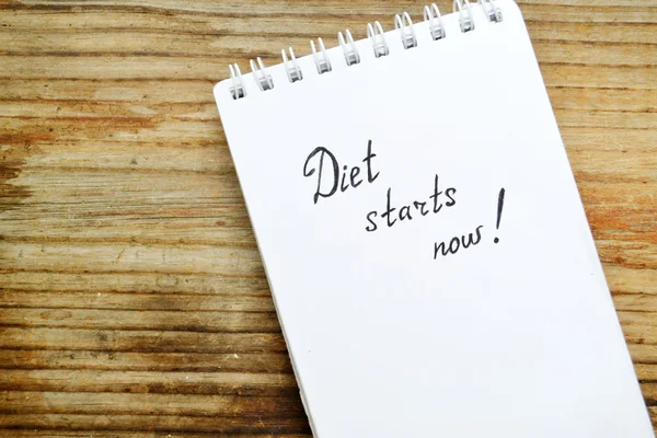 Diet concept with a notebook saying to start loosing weight on wooden table — Stock Photo, Image