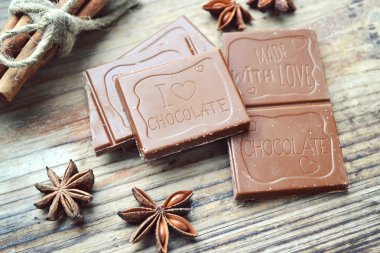 Yıldız anason ve tahta masada tarçın ile sütlü çikolata parçası