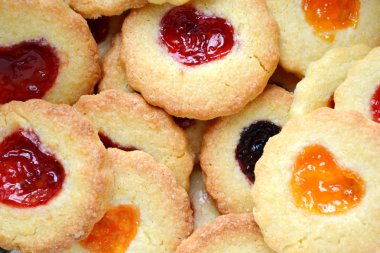 Ahşap masa üzerinde kalp şeklinde reçelli ev yapımı kurabiye