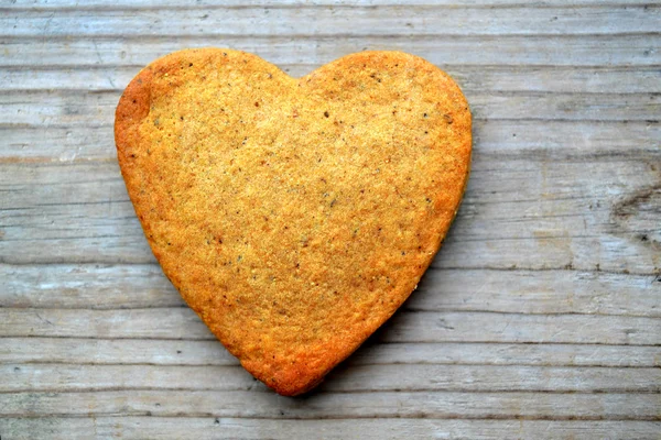 Gingerbread cookies in shape of heart on wooden table — Stock Photo, Image