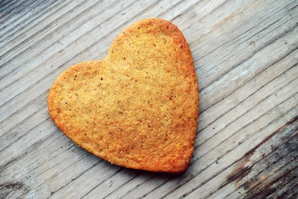 Gingerbread cookies in shape of heart on wooden table — Stock Photo, Image