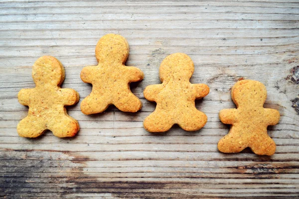 Galletas de jengibre en forma de hombre sobre mesa de madera —  Fotos de Stock