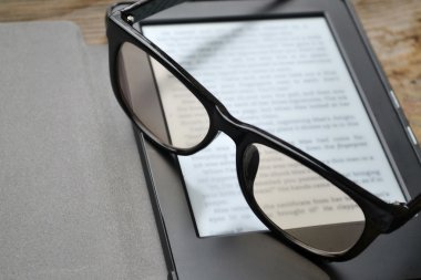 Ahşap masa retro gözlüklerle siyah ereader