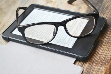 Ahşap masa retro gözlüklerle siyah ereader