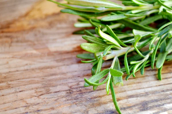 Fresh rosemary herb on wooden table — Stock Photo, Image