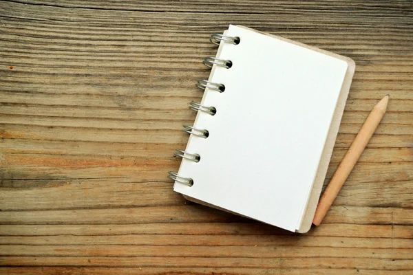 Un cuaderno retro vacío con papel viejo y lápiz pequeño — Foto de Stock