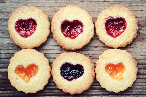 Homemade cookies with heart shaped jam on wooden table — Stock Photo, Image