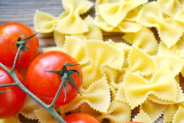 Küçük kırmızı kiraz domates ve kelebek makarna farfalle ahşap tablo şeklinde