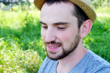 Genç adam sakallı ve şapkalı gülerek ve gülümseyerek