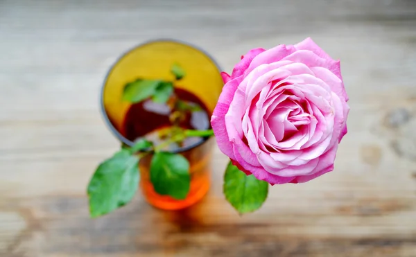 Rosa rosa en un pequeño jarrón sobre una mesa de madera —  Fotos de Stock