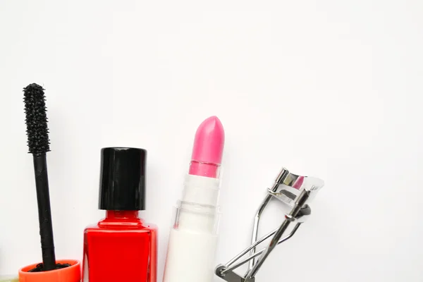 Cosmetics set with black mascara, pink and red nail polish and lipstick and eyelash curler isolated on white — Stock Photo, Image