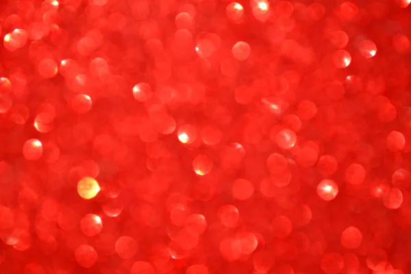 Fond rouge flou lumineux et abstrait avec des paillettes chatoyantes — Photo