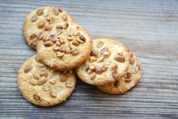 Tasty biscuits with candied peanuts on wooden table — Stock Photo, Image