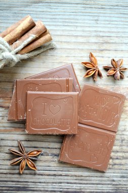 Yıldız anason ve tahta masada tarçın ile sütlü çikolata parçası