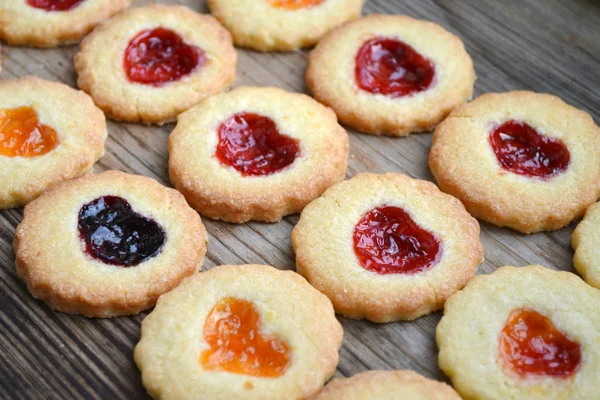 Homemade cookies with heart shaped jam on wooden table — Stock Photo, Image