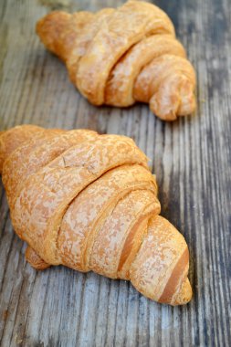 Ahşap masa üzerinde iki taze Fransız ay çöreği