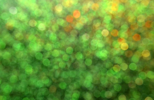 Fond vert flou lumineux et abstrait avec des paillettes dorées chatoyantes — Photo