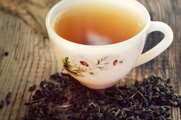 Té de manzanilla en una taza blanca vintage con flores de margarita en la mesa de madera — Foto de Stock