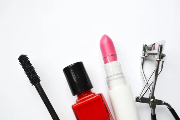 Cosmetics set with black mascara, pink and red nail polish and lipstick and eyelash curler isolated on white — Stock Photo, Image