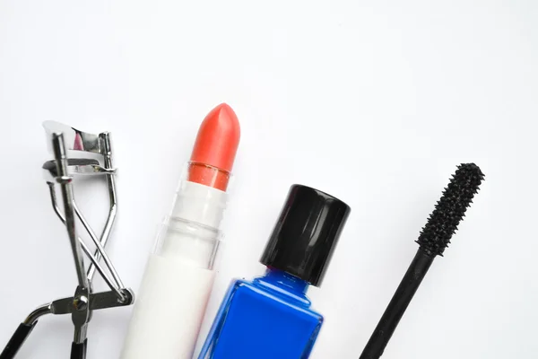 Cosmetics set with black mascara, blue and red nail polish and lipstick and eyelash curler isolated on white — Stock Photo, Image