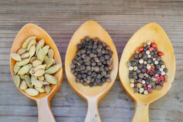 Quatre cuillères pleines d'épices différentes - cardamome, étoiles d'anis et poivrons — Photo