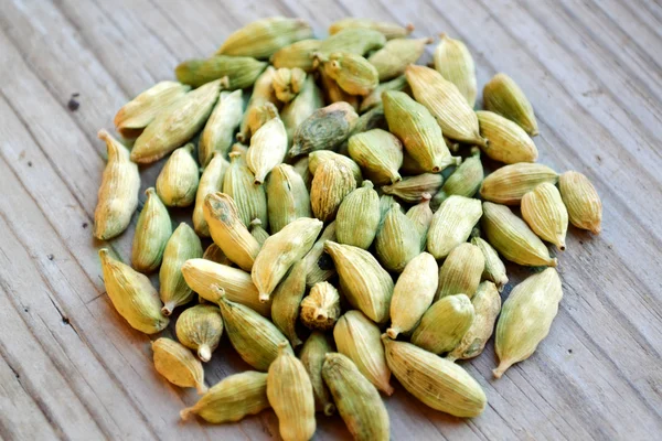 Graines de cardamome verte en forme de cercle sur table en bois — Photo