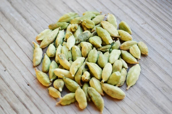 Green cardamom seeds in shape of circle on wooden table — Stock Photo, Image