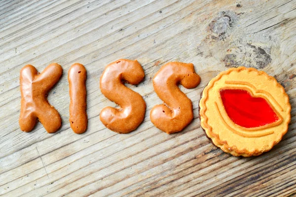 Λέξη φιλί από το αλφάβητο σοκολάτας μπισκότα στο ξύλινο τραπέζι — Φωτογραφία Αρχείου