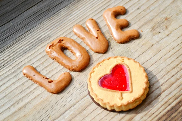 Αγάπη λέξη από το αλφάβητο σοκολάτας μπισκότα στο ξύλινο τραπέζι — Φωτογραφία Αρχείου
