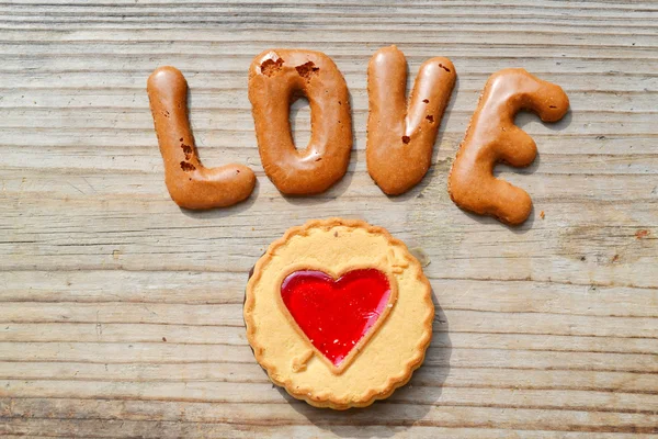 Word Love made of alphabet chocolate cookies on wooden table — Stock Photo, Image