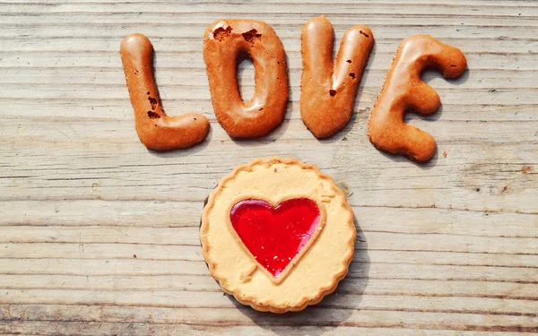Word Love made of alphabet chocolate cookies on wooden table — Stock Photo, Image