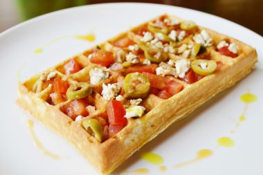 Belgian waffle with tomatoes, cheese and olives clipart